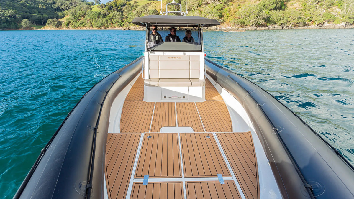 Wide brown faux-teak bow deck panels with aligned grooves and separate hatch outlines on an inflatable boat
