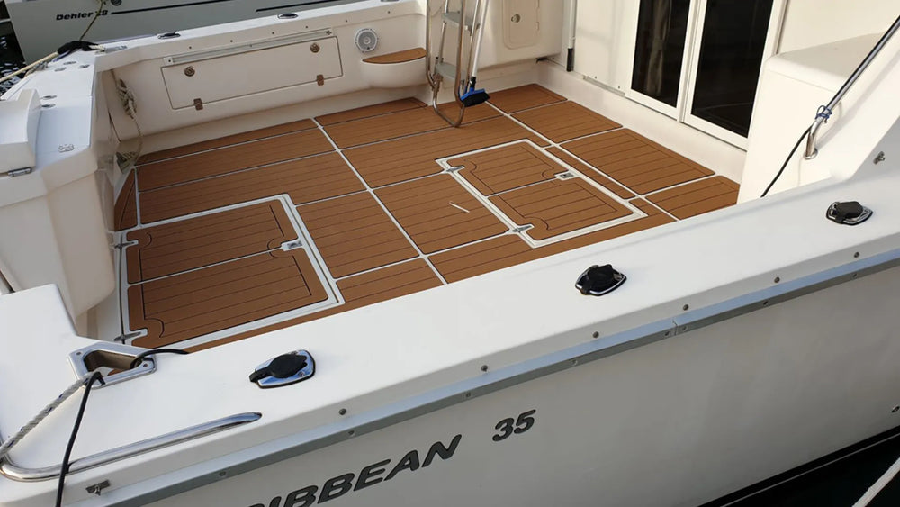 Brown faux-teak boat cockpit flooring with outlined hatch panels and aligned grooves near the cabin entrance
