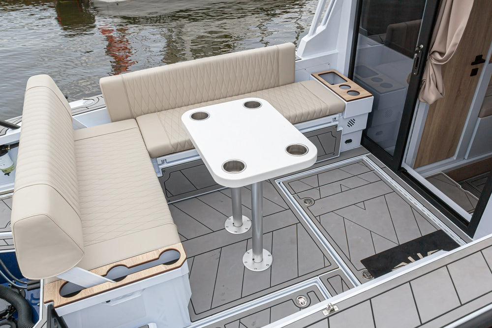 Grey boat cockpit flooring panels fitted around a table base and seating, illustrating a deck covering layout